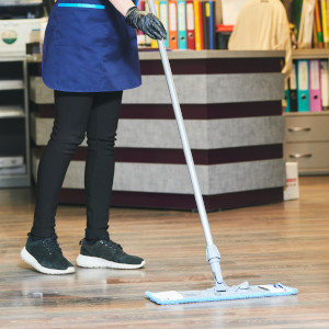 Mitarbeiterin reinigt Besucherempfang im Büro