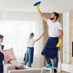 Ein Mitarbeiter entfernt bei der Grundreinigung Spinnweben