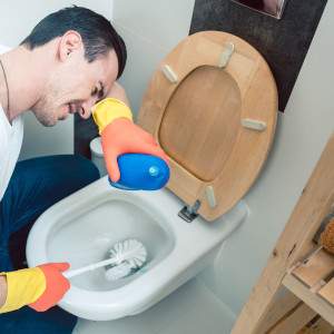 Ein Mann bei der Reinigung eines WC´s