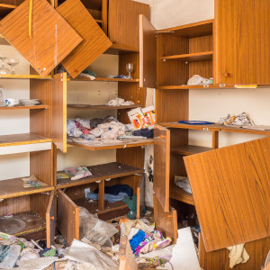 Völlig durchwühlte und beschädigte Schränke nach einem Einbruch